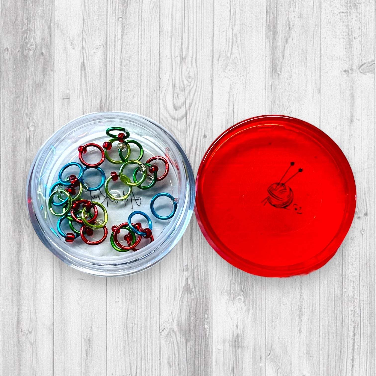 Christmas Sock Knitter's Companion Tiny Stitch Markers with Marker ConAdoreKnitThe Christmas Sock Knitter's Companion!! These tiny stitch markers are perfect for sock knitters. Designed to fit needle sizes: 0-1 US (2-2.5mm). This little set is Companion Tiny Stitch Markers