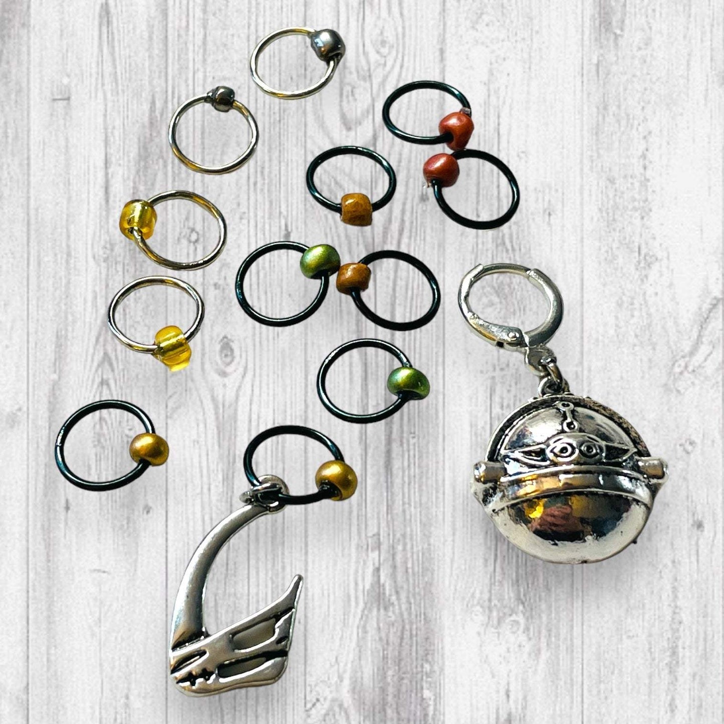 Mudhorn Clan Progress and Stitch MarkersAdoreKnitNext Generation Bounty Hunter Progress and Stitch Markers. Inspired by The Mandalorian, Din Djarin from the Mandalorian Series.  The prefect gift for a knitter! ThesMudhorn Clan Progress