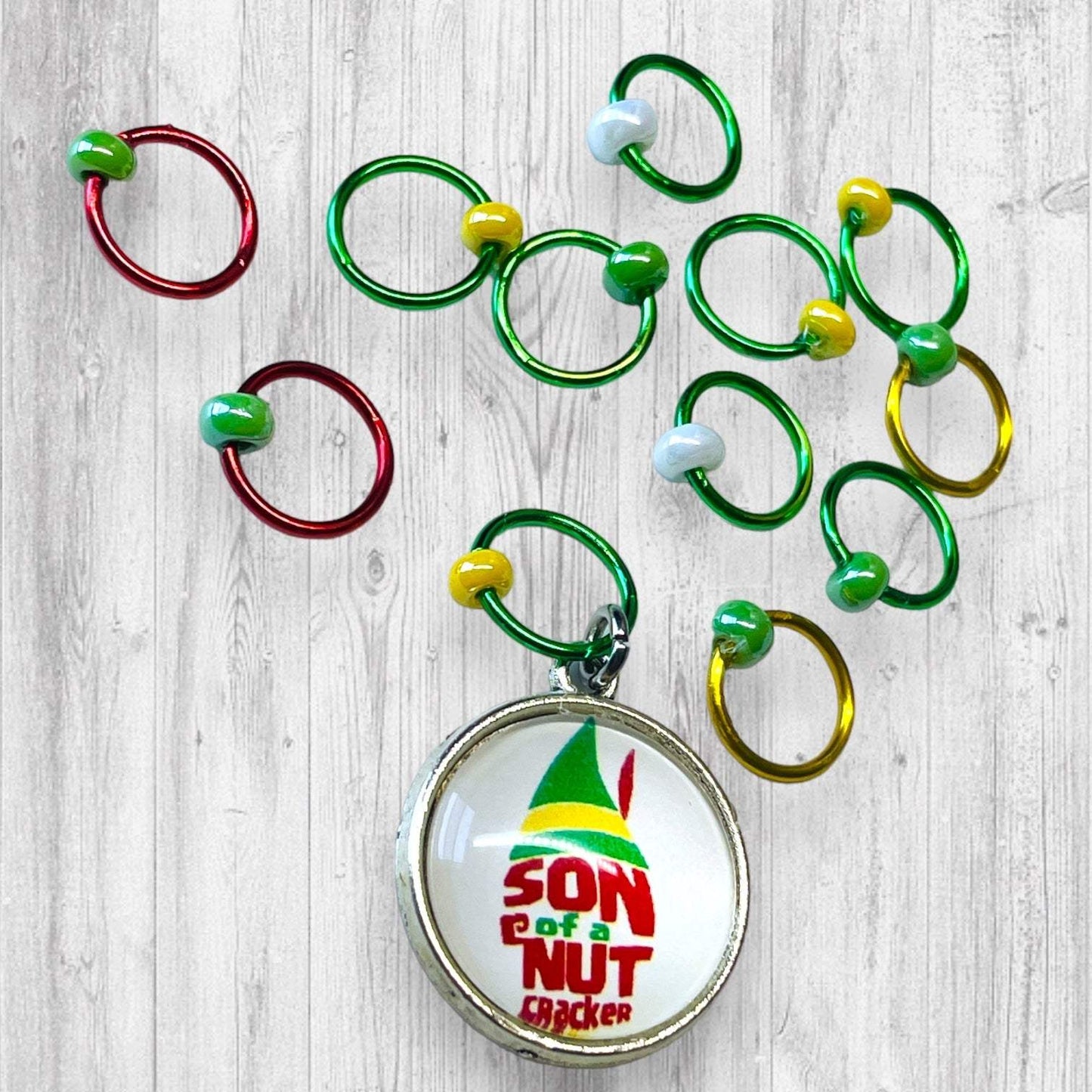 Son of a Nutcracker! Progress and Stitch MarkersAdoreKnit"Son of A Nutcracker" or "Santa OMG I Know Him!” Stitch Markers and Progress Marker. Based on the beloved 2003 movie with Buddy the Elf. Great for your holiday knittStitch Markers