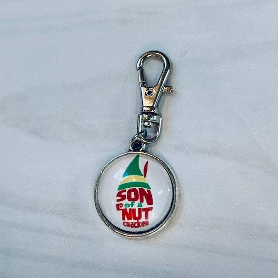 Son of a Nutcracker! Progress and Stitch MarkersAdoreKnit"Son of A Nutcracker" or "Santa OMG I Know Him!” Stitch Markers and Progress Marker. Based on the beloved 2003 movie with Buddy the Elf. Great for your holiday knittStitch Markers