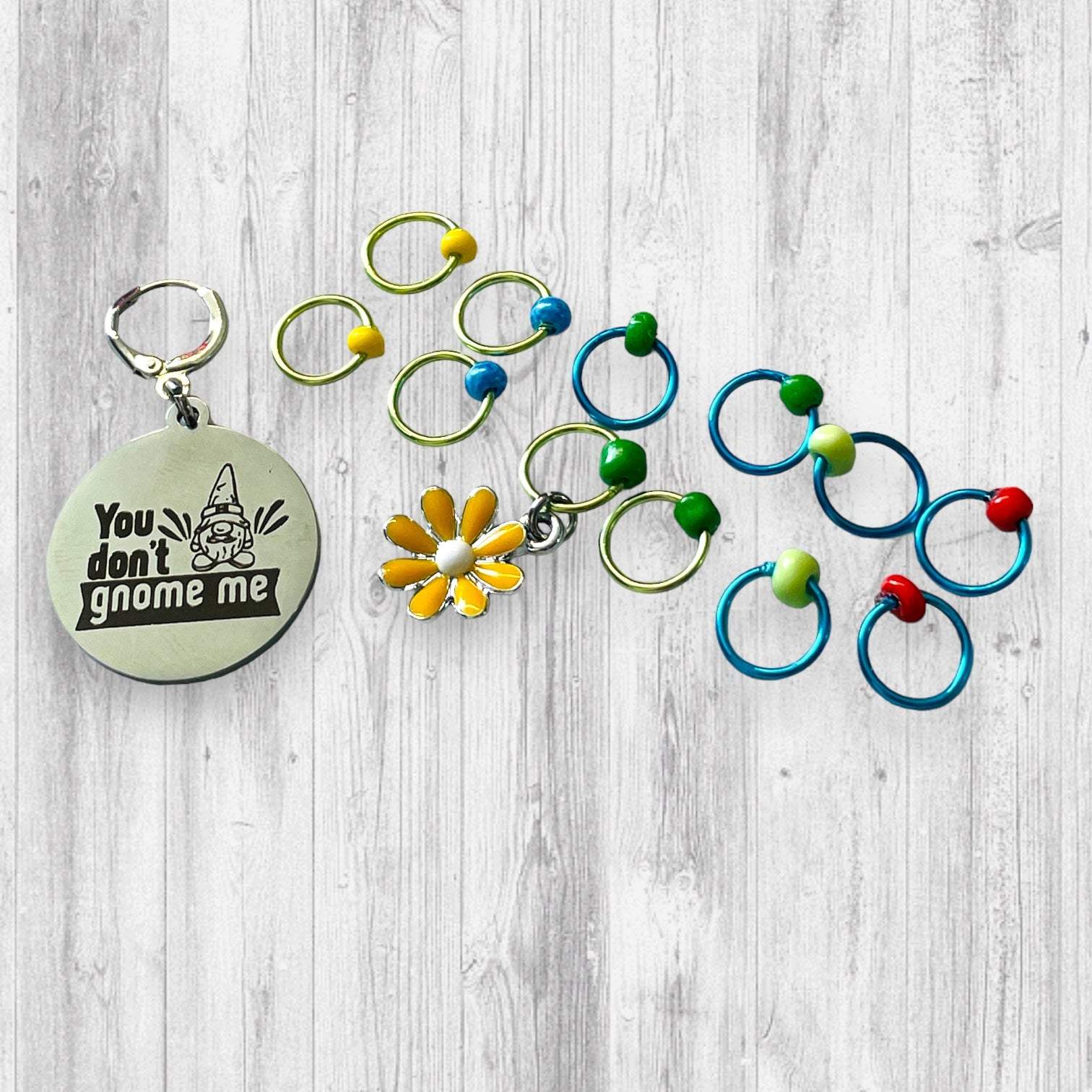 You Don't Gnome Me Progress and Stitch MarkersAdoreKnitYou Don't Gnome Me Progress and Stitch Markers. We couldn't decide if the Gnome house or the daisy went better for this set, so you decide!  Both match perfectly witStitch Markers